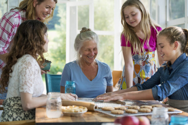 family gathered around a kitchen table making cookies together