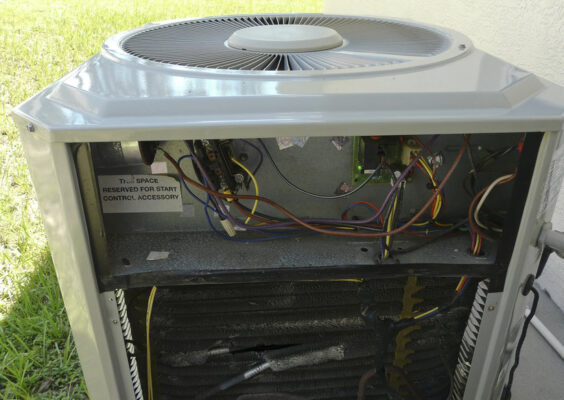 HVAC tech performing maintenance on outdoor ac unit