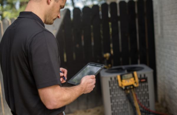 technician performing maintenance on an outdoor ac unit