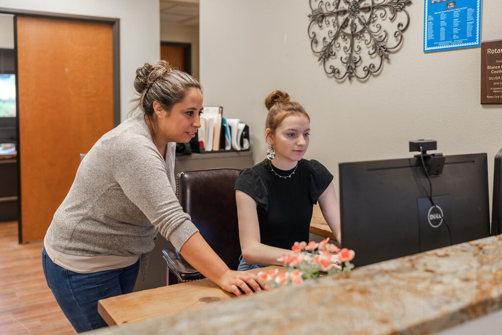Blanco customer service representative smiling and working at computer